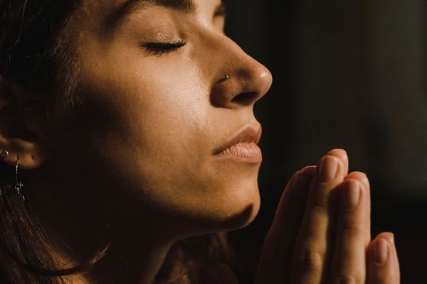 Close up of a person meditating with calm expression.